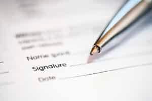 Close-up detail of a signature form with a ballpoint pen