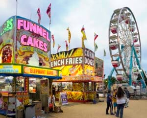 a spinning thrill ride at the Minnesota State Fair is lit up against the colors of the sky